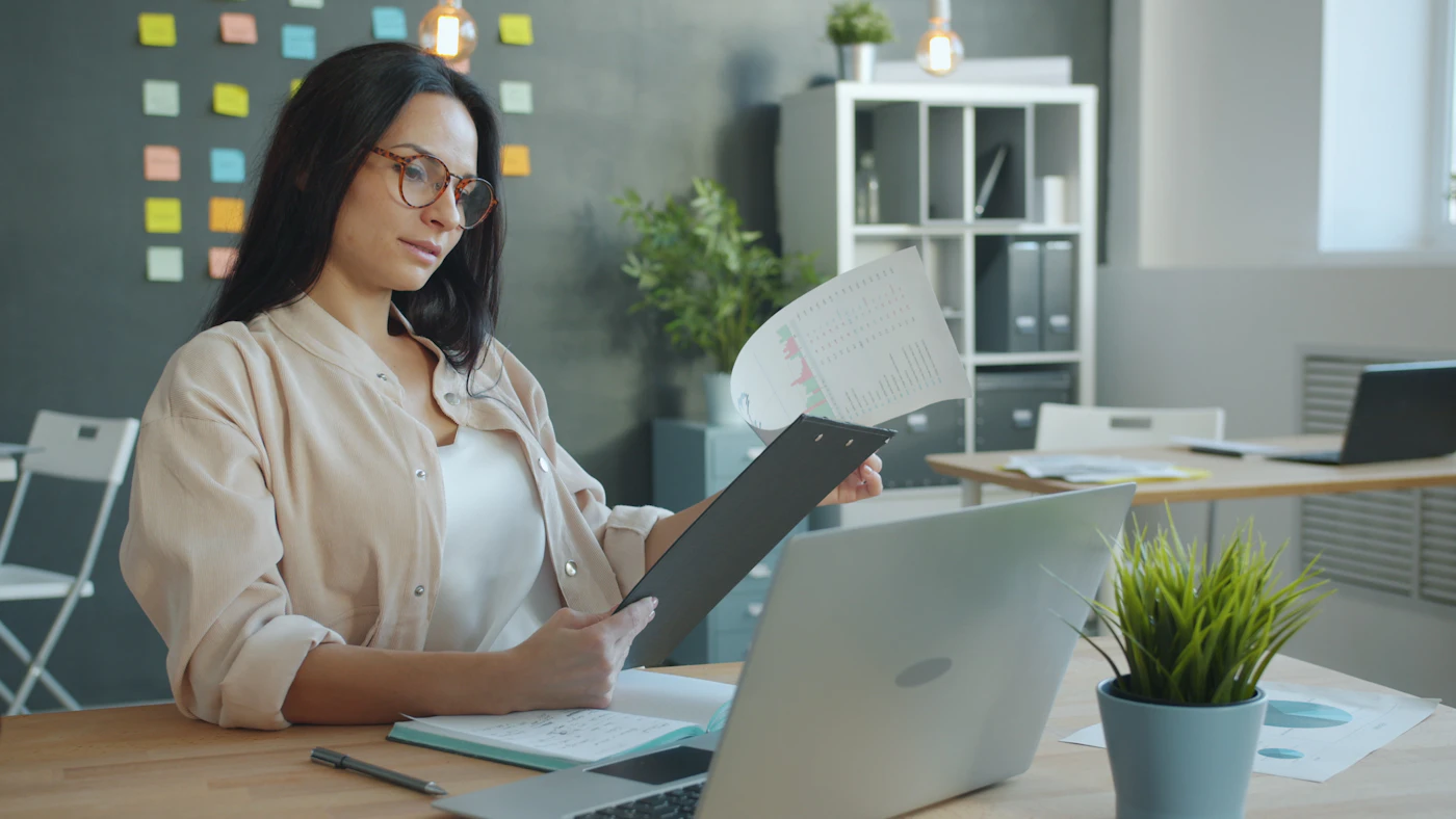Professionnelle qui vérifie des documents de conformité à un bureau